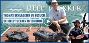 Ein Mann kniet auf einem Steg neben zwei Unterwasser-Roboterfahrzeugen. Text: „Thomas Schlageter zu Besuch bei Deep Trekker in Toronto“.